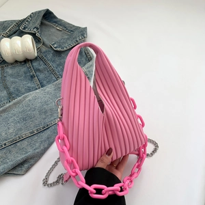 Detail of bright pink pleated PU shoulder bag featuring chunky resin and metal chains
