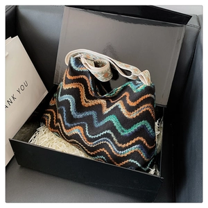 Détail du sac à bandoulière en laine bohème avec sangle ethnique dans un coffret