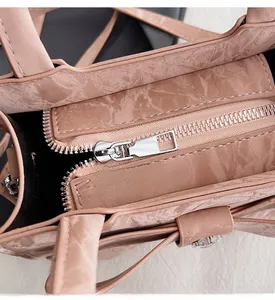 Detail view of the silver metal zipper on a pink marble-textured women's handbag