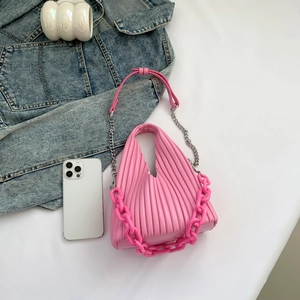 Detail of pink pleated PU leather handbag with trendy chunky plastic chain and crossbody strap