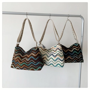 Détail de sacs bohèmes en maille avec rayures ondulées colorées et larges bandoulières