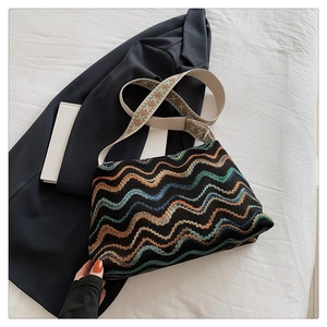 Gros plan détaillé du sac seau en laine bohème avec motifs ondulés colorés et bandoulière