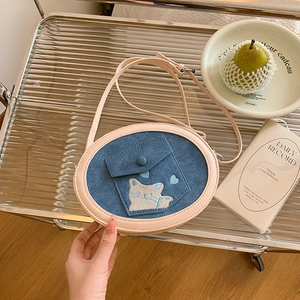 Close-up of cute cat embroidery and denim pocket on stylish crossbody bag for women
