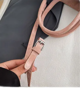 Detailed macro view of the silver metal adjustment buckle on the pink shoulder strap