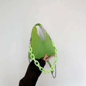 Detail of green pleated triangle handbag with chunky acrylic and silver metal chains