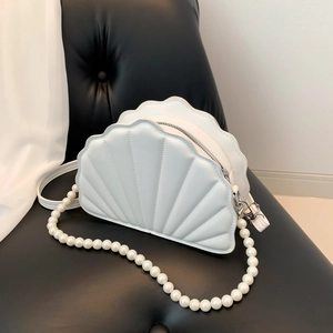 Close-up of white shell shaped bag with radial quilting and pearl chain detail