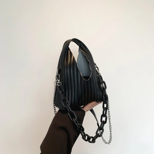 Detail of black pleated PU handbag featuring resin and silver metal chain straps