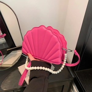 Detailed shot of bright pink shell-shaped PU leather bag with white pearl handle