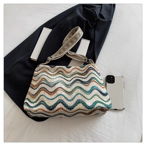 Détail du sac bohème en laine tissée avec motifs de vagues colorées et sangle géométrique