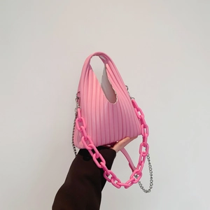 Detailed shot of pink pleated handbag featuring bold acrylic and fine silver metal chains