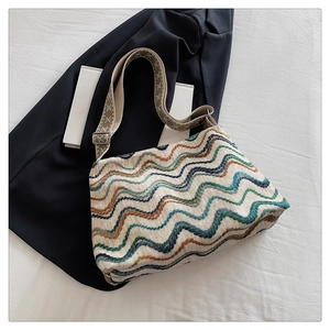 Détail du sac bohème en laine à motifs ondulés avec une large bandoulière tissée