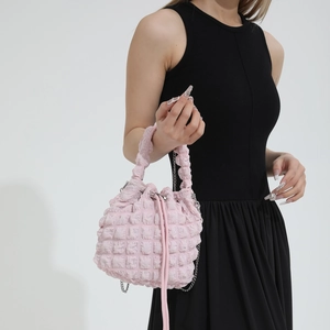 Close-up of pink ruched cloud bucket bag with textured quilted fabric and silver chain
