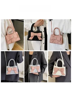 Detail view of mini bow handbags in pink, black, silver and white with crossbody straps