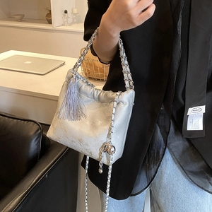 Detailaufnahme der silbernen Wolken-Tasche mit Metallfransen und Leder-Kettengurt