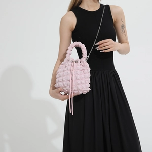 Detailed macro view of a light pink bubble texture drawstring bucket bag with silver hardware