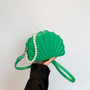 Detail of green shell-shaped bag with premium pearl handle and textured PU leather