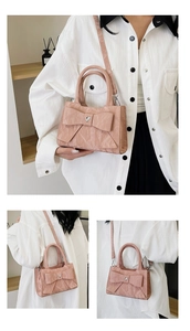 Detail of light pink shoulder bag featuring pleated texture and heart crystal bow