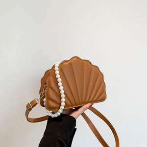 Detail of shell-shaped shoulder bag in brown PU with pearl chain and 3D texture