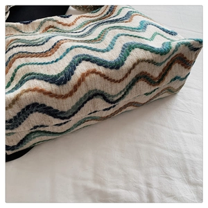Gros plan du sac seau bohème tissé avec broderie ondulée colorée et texture riche