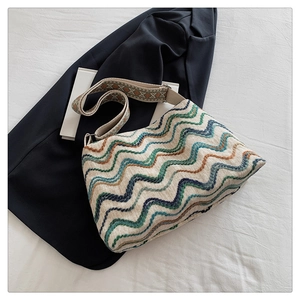 Détail du sac seau bohème en tricot avec rayures ondulées et bandoulière tissée
