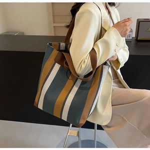 Detail of large striped canvas tote bag showing spacious capacity and premium shoulder handles