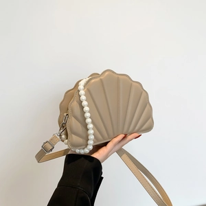 Detail view of khaki shell-shaped PU leather bag with quilt pattern and pearl handle chain