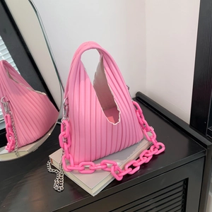 Close-up of pink pleated PU leather handbag with resin and silver metal chain straps