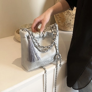 Detailansicht der silbernen Plisseetasche mit Metallkette und Seidenquasten-Dekoration