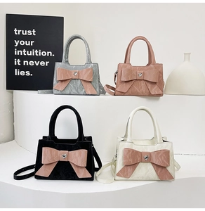 Detailed view of four small pleated bags with oversized bows and heart crystal accents