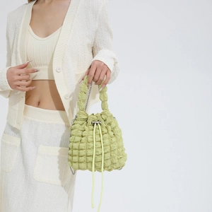 Detail of green ruched cloud bucket bag with silver chain and textured bubble fabric