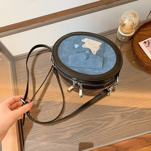 Detail of blue denim crossbody bag featuring cute cat embroidery and heart accents