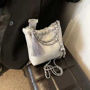 Detail der silbernen Satin-Beuteltasche mit Fransen und gesteppter Metallkugel-Kettenverstellung