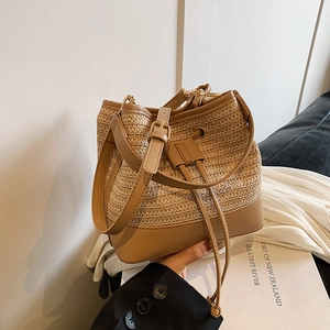 Détail d'un sac seau en paille tressé avec bordure en cuir de qualité et cordon de serrage