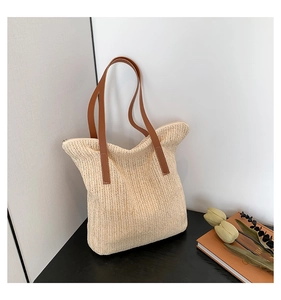 Détail du sac fourre-tout en paille tissé main avec lanières en cuir marron et zip