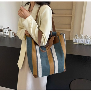 Side view of striped canvas tote bag showing large capacity and reinforced leather corners