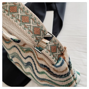 Détail du sac seau en tricot bohème avec motifs à vagues et bandoulière géométrique