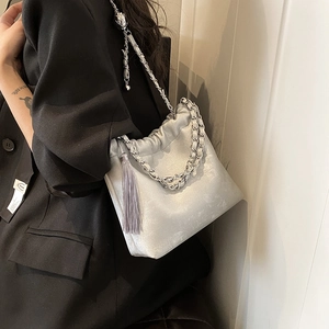 Detailsicht der silbernen Plisse-Eimertasche mit Metallkette und modischen Quasten