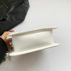 Detail view of white PU shell bag showing base thickness, side structure and pearl decor