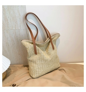 Vue détaillée du sac cabas en paille tissée avec anses en simili cuir marron et fermeture