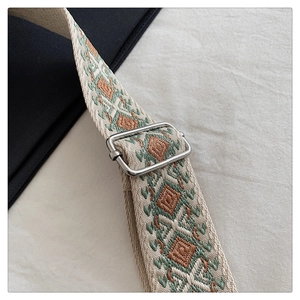 Détail de la bandoulière bohème tissée avec motifs géométriques et boucle en métal argenté