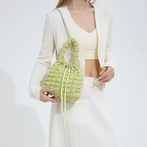 Detail of light green popcorn fabric bucket bag showing 3D texture and chain strap
