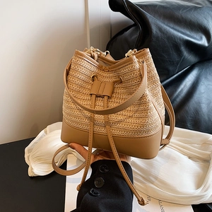 Détail de la texture tressée et du cordon en cuir marron du sac seau bohème