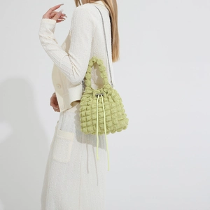 Detailed shot of avocado green bubble cloud bucket bag with drawstring and silver chain
