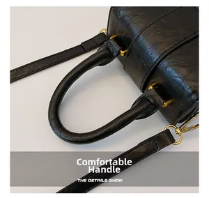 Detail shot of the comfortable thick handle and black crinkle texture of the mini bag