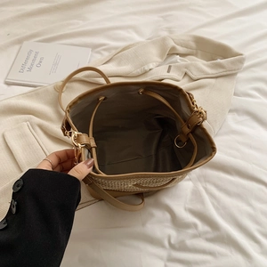 Détail du sac seau tissé avec bordure en cuir marron et doublure intérieure à cordon