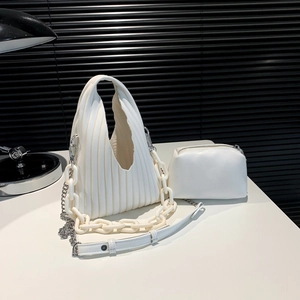 Detailed view of white pleated PU handbag with chunky plastic chain and metal shoulder strap