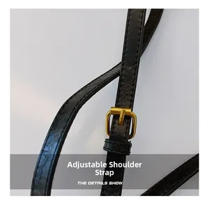 Detail view of adjustable black leather strap with gold buckle and stitching texture