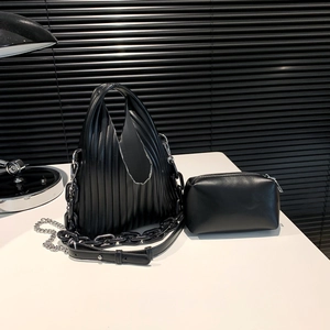 Detail view of black pleated shoulder bag with chain strap and matching zipper pouch