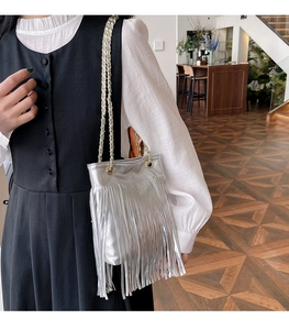 Vue détaillée du sac à bandoulière argenté avec glands métalliques et chaîne dorée