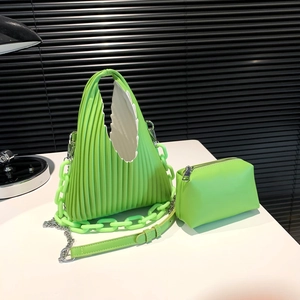 Detail of bright green pleated tote bag with chunky plastic chain and small matching pouch